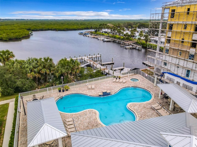 view of pool featuring a boat dock, a water view, and a patio