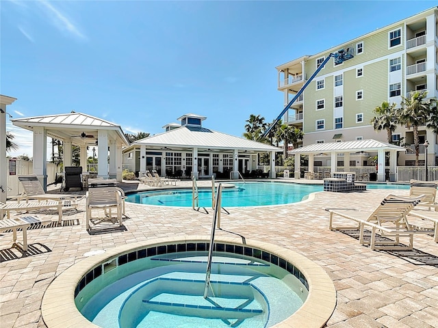 1 Riverwalk Dr Unit 302, New Smyrna Beach, FL 32169 - pool with a ceiling fan, a patio area, a community hot tub, and fence