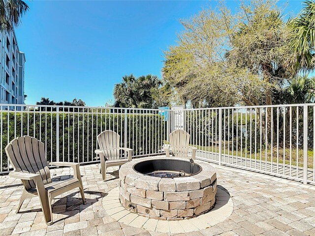 1 Riverwalk Dr Unit 302, New Smyrna Beach, FL 32169 - view of patio featuring fence and a fire pit