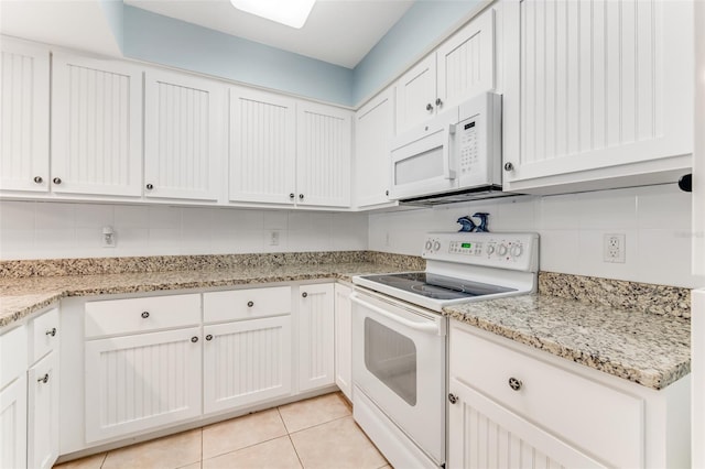 kitchen with white appliances, light tile patterned floors, and white cabinets