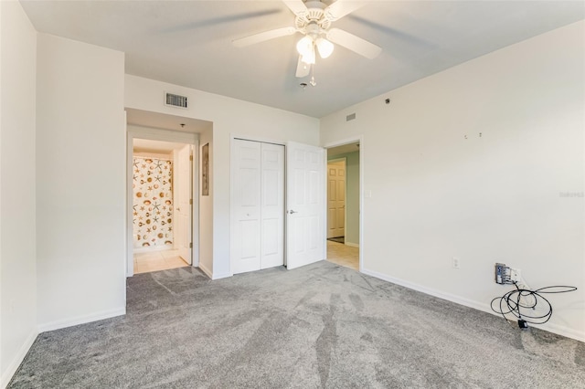 unfurnished bedroom featuring carpet, ceiling fan, and a closet