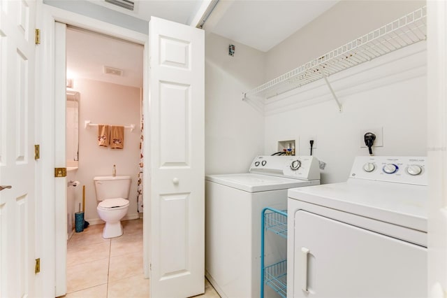 laundry area featuring light tile patterned floors and independent washer and dryer