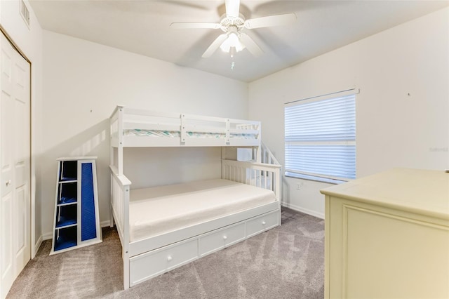 unfurnished bedroom featuring carpet floors, ceiling fan, and a closet