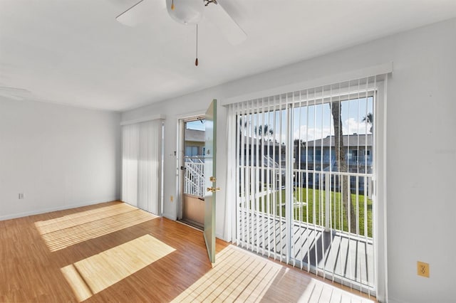 unfurnished room featuring ceiling fan, a wealth of natural light, and light wood-type flooring