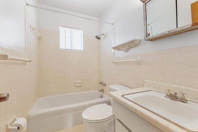 full bathroom featuring tiled shower / bath combo, tile walls, tile floors, vanity with extensive cabinet space, and toilet