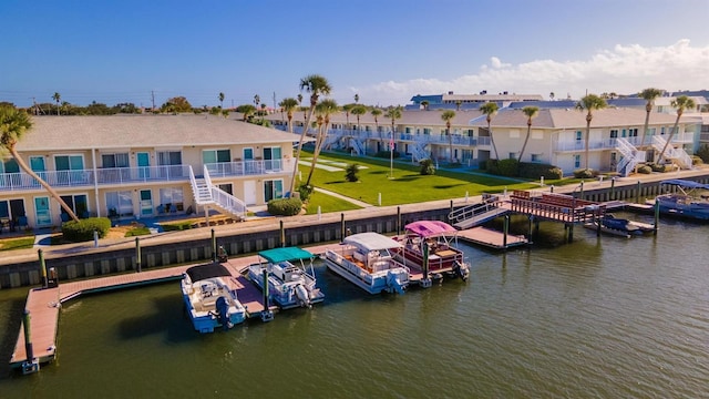 dock area featuring a balcony, a lawn, and a water view