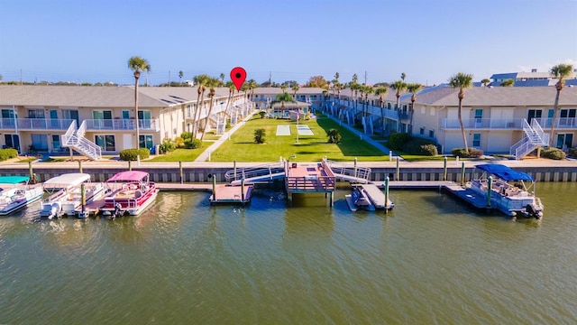 dock area with a yard, a balcony, and a water view