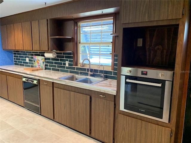 kitchen featuring tasteful backsplash, sink, oven, and dishwasher