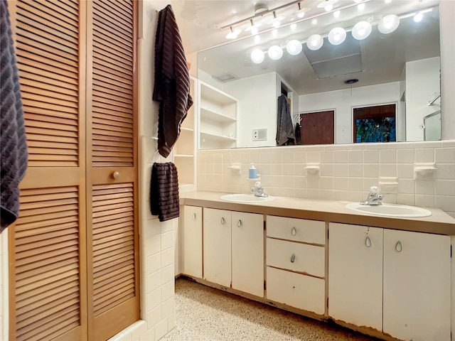 bathroom featuring tasteful backsplash, vanity, and tile walls