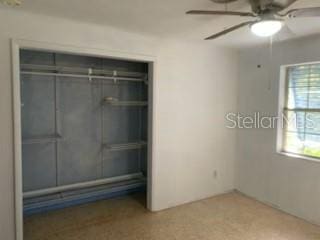 unfurnished bedroom featuring ceiling fan and a closet