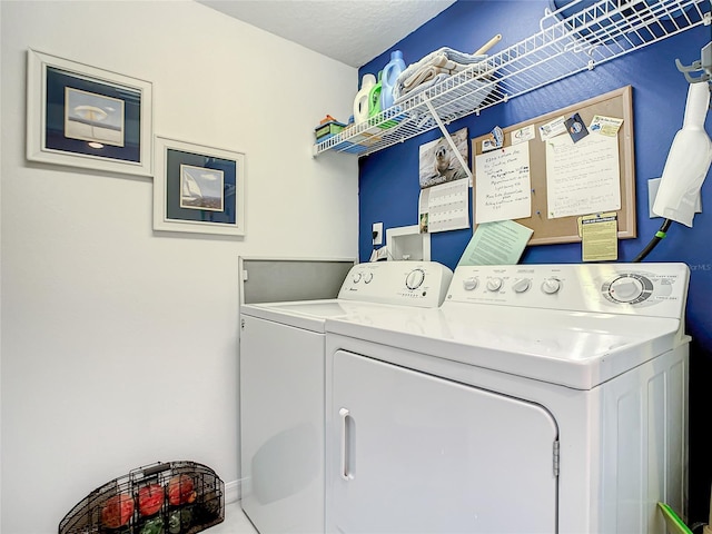 clothes washing area featuring a textured ceiling and washing machine and clothes dryer