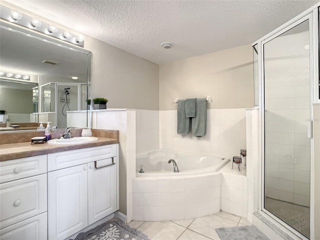 bathroom with vanity, a textured ceiling, tile patterned floors, and separate shower and tub