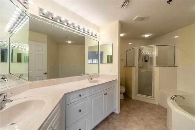 full bathroom featuring a textured ceiling, toilet, dual vanity, tile patterned floors, and separate shower and tub