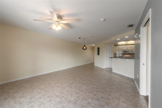 5300 S Atlantic Ave Unit 8502, New Smyrna Beach, FL 32169 - unfurnished living room with light tile patterned flooring, visible vents, baseboards, and a ceiling fan