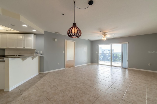 interior space with light tile patterned floors and ceiling fan