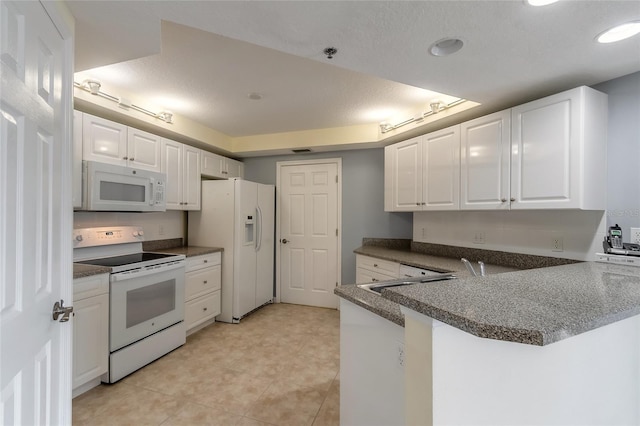 kitchen with light tile patterned flooring, white appliances, a textured ceiling, white cabinets, and kitchen peninsula