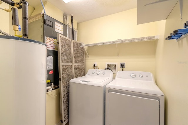 washroom featuring water heater and separate washer and dryer