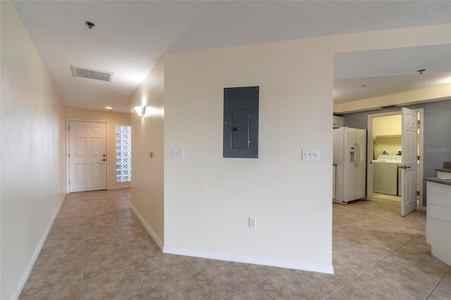 hallway featuring washer / clothes dryer, electric panel, and light tile patterned floors