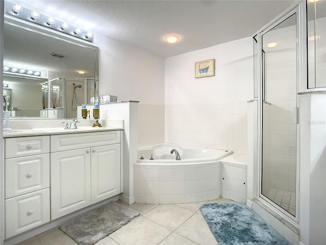 bathroom featuring vanity, separate shower and tub, tile patterned floors, and a textured ceiling