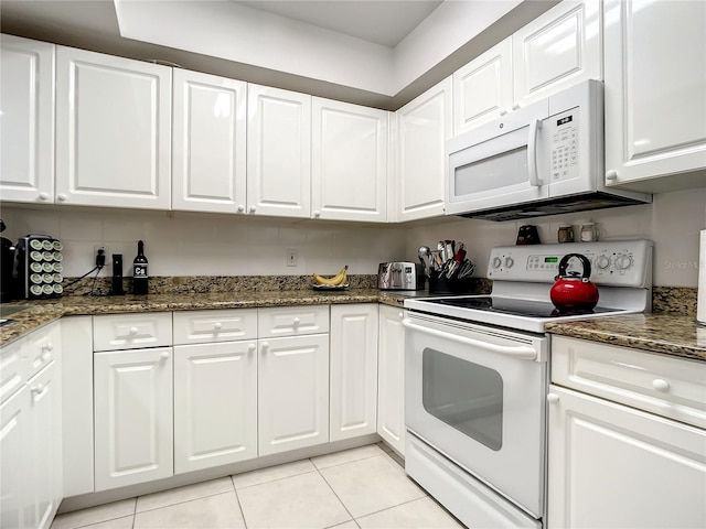 kitchen featuring white cabinetry, white appliances, dark stone countertops, and light tile patterned floors