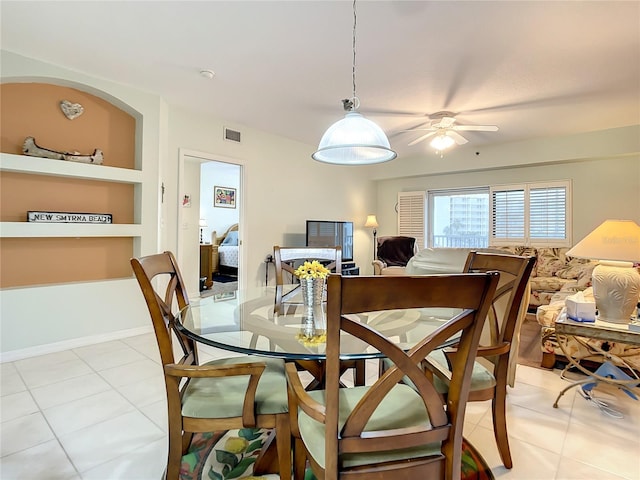 tiled dining room with built in features and ceiling fan