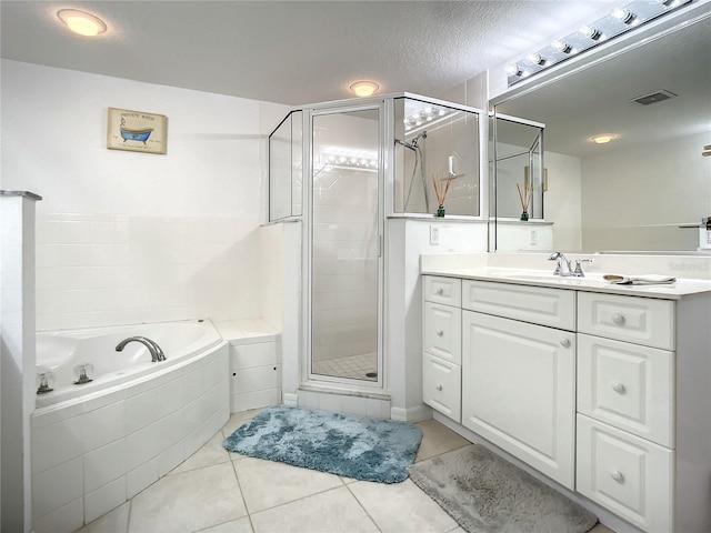 bathroom featuring plus walk in shower, tile patterned floors, a textured ceiling, and vanity