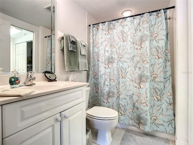 bathroom featuring tile patterned flooring, vanity, a textured ceiling, and toilet