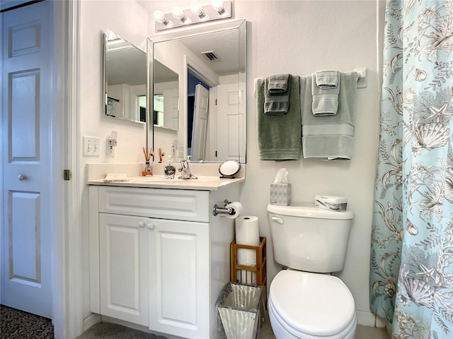 bathroom featuring vanity, toilet, and curtained shower