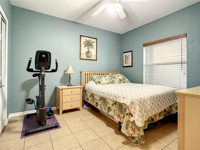 bedroom featuring a textured ceiling, ceiling fan, and light tile patterned flooring