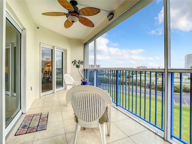 balcony featuring a water view and ceiling fan