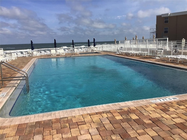 pool featuring a water view and fence