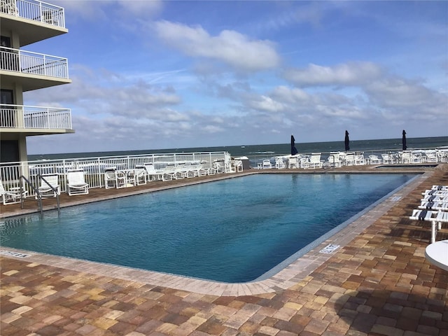 view of swimming pool featuring a water view