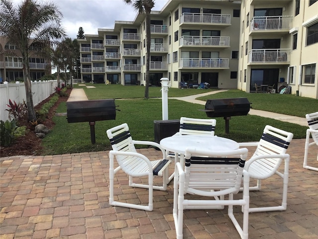 view of home's community featuring a patio area and a lawn