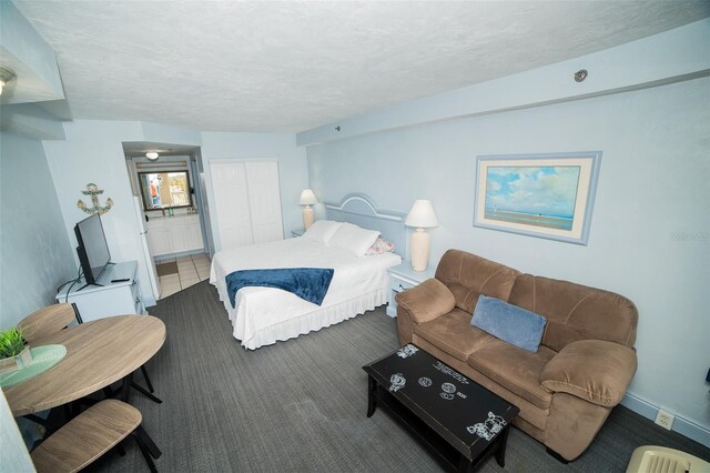 2700 N Atlantic Ave Unit 517, Daytona Beach, FL 32118 - bedroom featuring a closet, carpet flooring, connected bathroom, and a textured ceiling
