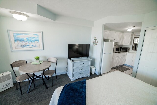 2700 N Atlantic Ave Unit 517, Daytona Beach, FL 32118 - kitchen with freestanding refrigerator, white cabinets, light countertops, stainless steel microwave, and carpet
