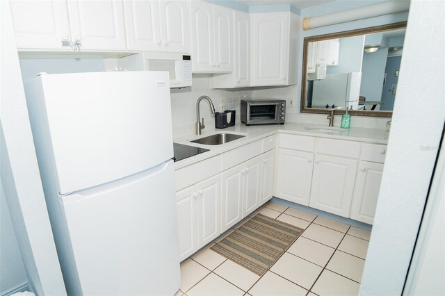 2700 N Atlantic Ave Unit 517, Daytona Beach, FL 32118 - kitchen with white appliances, white cabinets, tasteful backsplash, light countertops, and light tile patterned floors