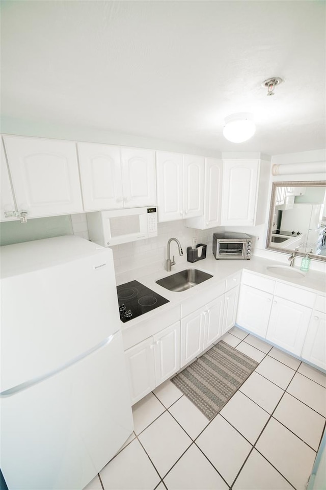 2700 N Atlantic Ave Unit 517, Daytona Beach, FL 32118 - kitchen featuring white appliances, white cabinetry, light tile patterned floors, light countertops, and backsplash