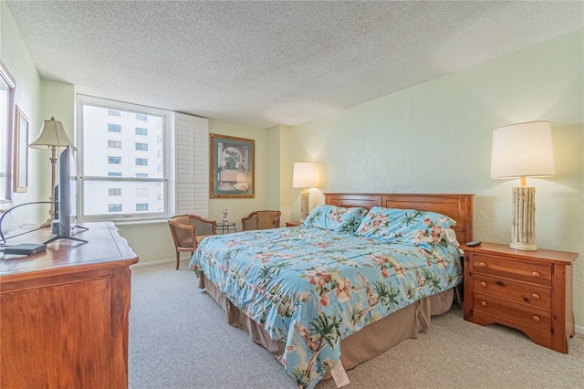 bedroom with light colored carpet and a textured ceiling