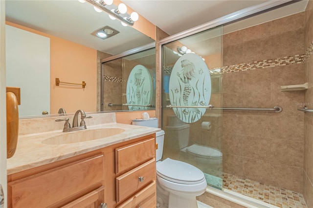 bathroom with toilet, a shower with door, and vanity