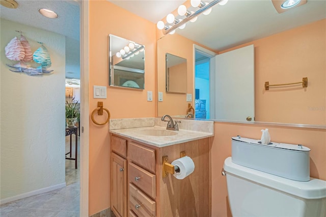 bathroom featuring toilet, vanity, and tile patterned flooring