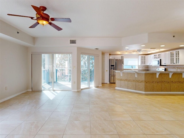 5300 S Atlantic Ave Unit 9201, New Smyrna Beach, FL 32169 - kitchen featuring ceiling fan, light tile floors, appliances with stainless steel finishes, tasteful backsplash, and white cabinetry