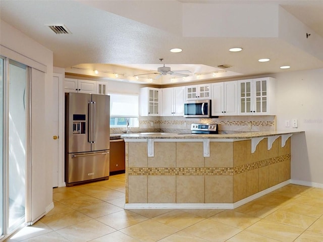 5300 S Atlantic Ave Unit 9201, New Smyrna Beach, FL 32169 - kitchen with a raised ceiling, stainless steel appliances, ceiling fan, and white cabinets