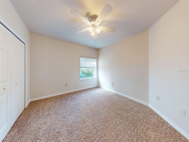 5300 S Atlantic Ave Unit 9201, New Smyrna Beach, FL 32169 - unfurnished bedroom featuring a closet, a textured ceiling, ceiling fan, and light colored carpet