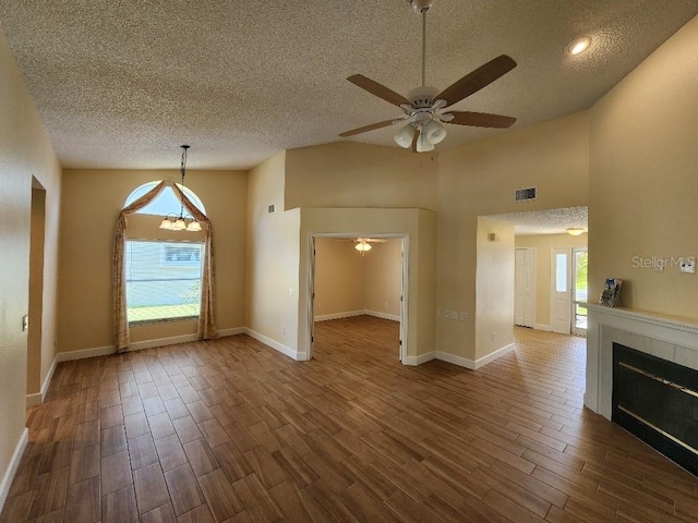 unfurnished living room with a wealth of natural light, ceiling fan, and a fireplace