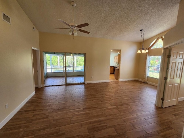 unfurnished room featuring high vaulted ceiling, a textured ceiling, ceiling fan with notable chandelier, and a wealth of natural light