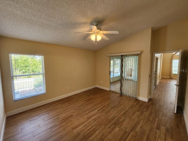 spare room featuring vaulted ceiling, ceiling fan, a textured ceiling, and dark hardwood / wood-style flooring