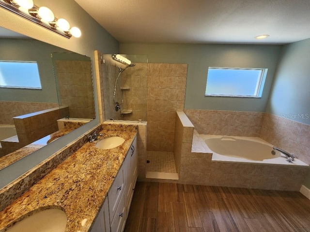 bathroom with plenty of natural light, shower with separate bathtub, hardwood / wood-style floors, and double vanity