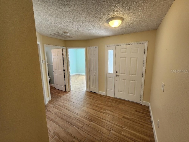 foyer entrance featuring light hardwood / wood-style floors and a textured ceiling