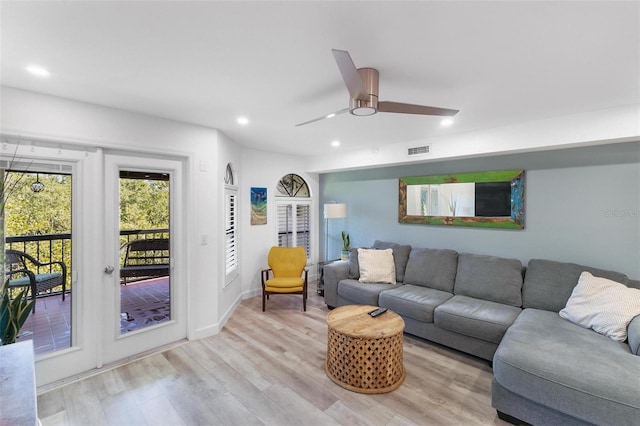 living room with light hardwood / wood-style floors and ceiling fan