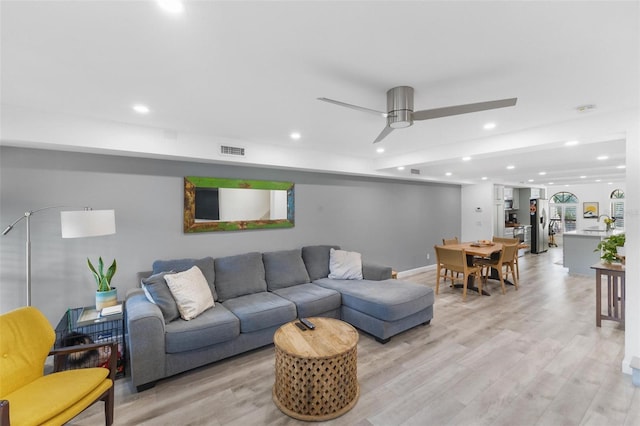 living room with sink, light hardwood / wood-style floors, and ceiling fan